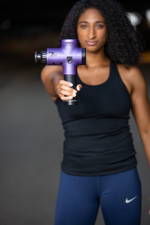women athlete holding total massage gun