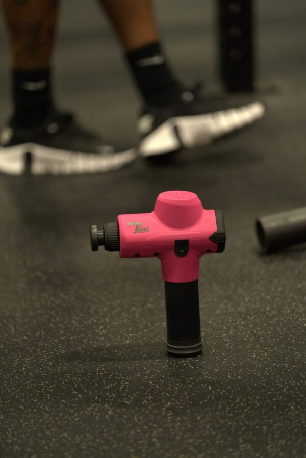 Hot Pink Massage Gun on Gym Floor